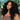 Model wearing Ali Grace Transparent Lace Front Natural Color Curly Human Hair Wig with soft defined curls, transparent lace and a natural-looking hairline.